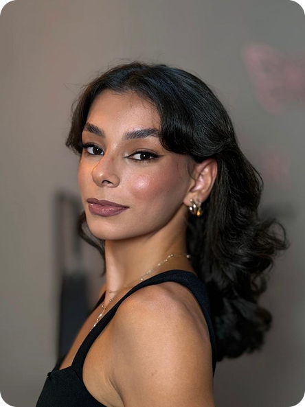 Foto de perfil de Jade Ferreira. Cabelo castanho escuro até os ombros, olhos castanhos e sorriso amigável